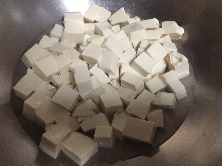 蟹粉豆腐,如图将豆腐倒入锅中加少许水，煮开；