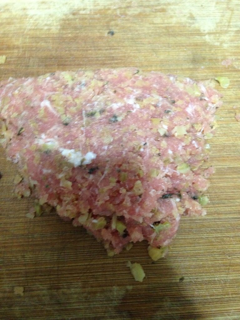 梅菜肉饼蒸腊肠,如图将剁碎的梅菜和猪肉混合在一起，继续一起剁。