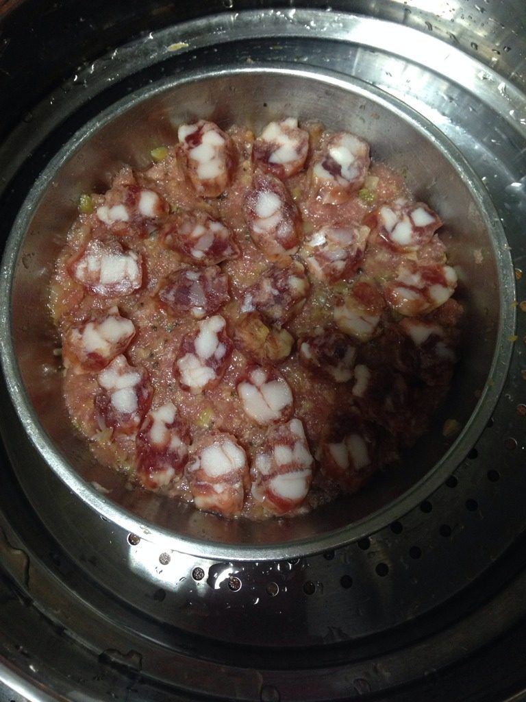 梅菜肉饼蒸腊肠,如图水烧开后放入锅里蒸15分钟。如果想省时间可以烧米饭的时候放到电饭锅里一起煮。饭好了肉也熟了。
