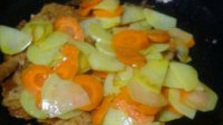 胡萝卜土豆炒锅巴,在倒入炒好的土豆和胡萝卜。