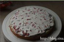 托马斯场景蛋糕,挖取适量奶油抹在草莓上；