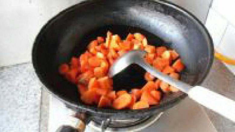 胡萝卜丁炒腰果,锅里放适量油把胡萝卜放进去翻炒。