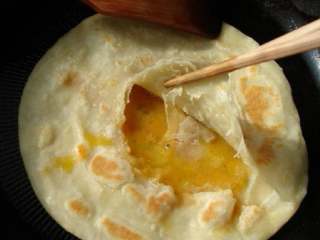 鸡蛋火腿灌饼,将筷子夹起一层饼皮，倒入蛋液。