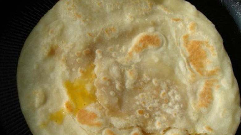 鸡蛋火腿灌饼,盖上饼皮，稍烙一会儿，翻面，烙至蛋液凝固即可。