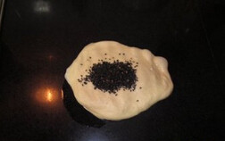 黑芝麻咸餐包,发好的面团取出排气，加入适量的黑芝麻，揉匀，分成4等份（约 65克一份），放一边松驰15分钟