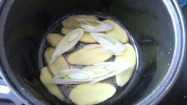 ≈电饭锅版烤鸡≈,电饭锅里抹薄薄一层油，把姜片和大葱片铺在底部