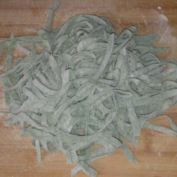 菠菜素哨子面,将擀好的面像折扇子一样，折起来切成面条。