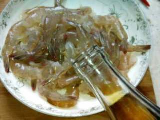 香辣干锅虾,把虾里的张东西弄干净，用小刀在虾背上划一条口子，洗干净放盘子里倒入料酒。