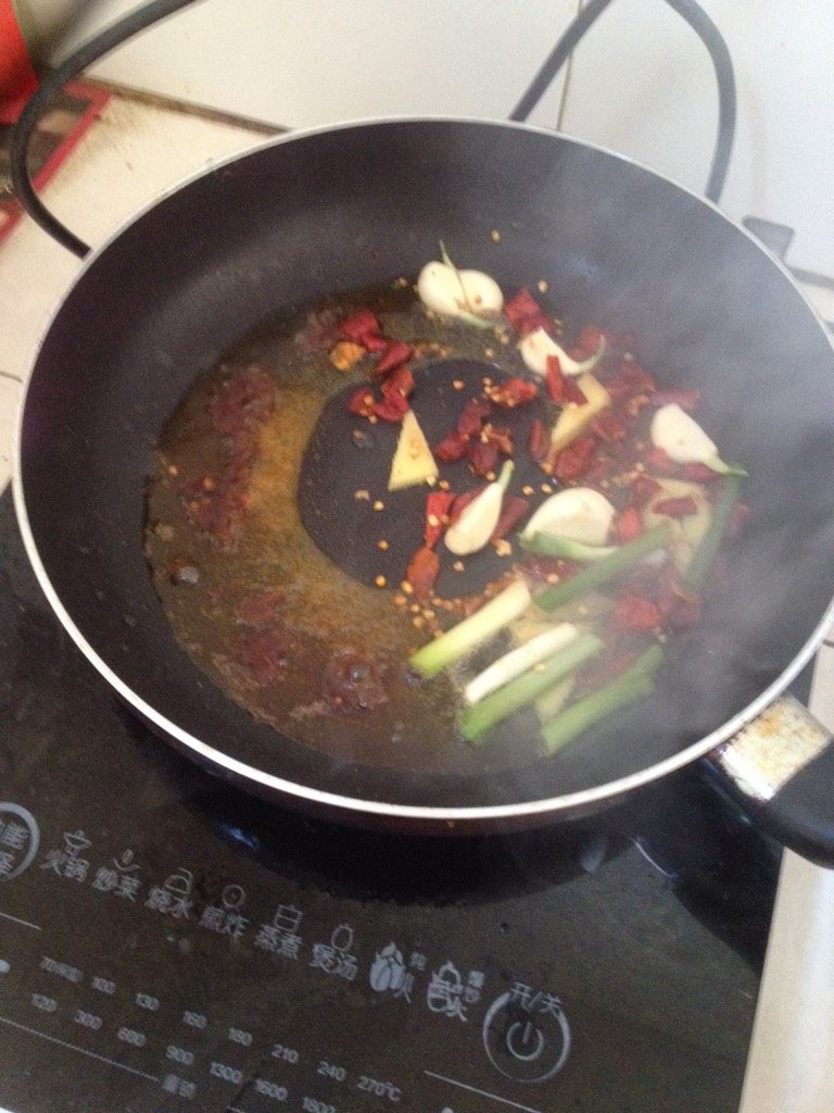 香辣干锅猪手,如图锅内放入多一点色拉油、爆香葱姜蒜