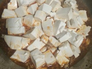 肉糜豆腐,如图水煮沸后倒入豆腐，加盖子煮3-4分钟；