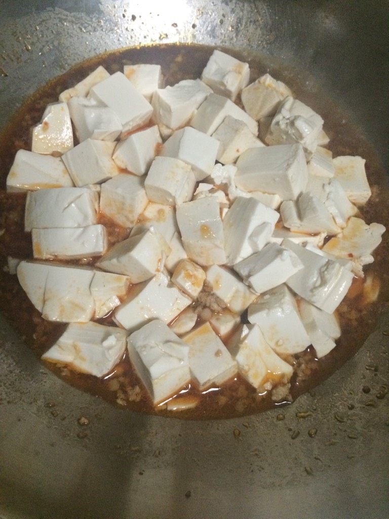 肉糜豆腐,如图水煮沸后倒入豆腐，加盖子煮3-4分钟；