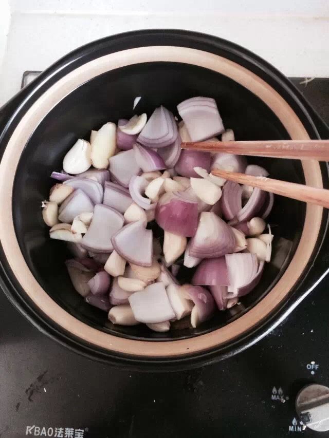 生啫鸡煲,油七成热放入准备好的洋葱蒜粒，姜片，翻炒