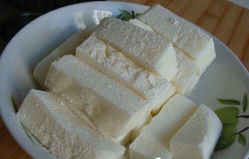 炸鲜奶,把切成小块的奶块先沾上淀粉，在挂脆皮桨