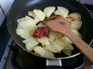 自创【香辣土豆片】,把土豆倒进去翻炒一下，在加适量豆瓣酱翻炒均匀。