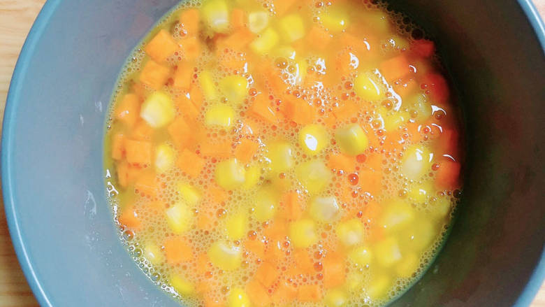 爆浆吐司,鸡蛋打散均匀，放入玉米粒和胡萝卜丁。