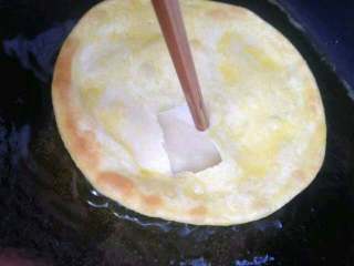 鸡蛋灌饼,在翻面用筷子搓一个洞打入鸡蛋（没拍打鸡蛋的照片）。