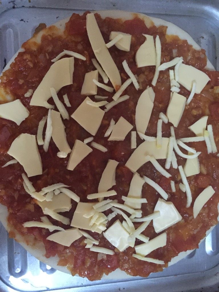 什锦披萨,披萨原胚抹上炒好的披萨酱，铺上一层奶酪，进微波炉微8分钟（150度）