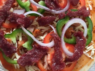 大虾牛肉披萨,在铺上一层马苏里拉，放入适量红绿青椒、洋葱、牛肉