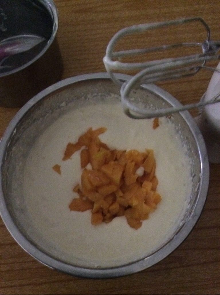芒果芝士蛋糕（免烤）8寸,将芝士糊倒进淡奶油中，用打蛋器低速搅拌均匀，加入芒果肉，用刮刀上下搅拌，搅拌其间把多余的气泡震出