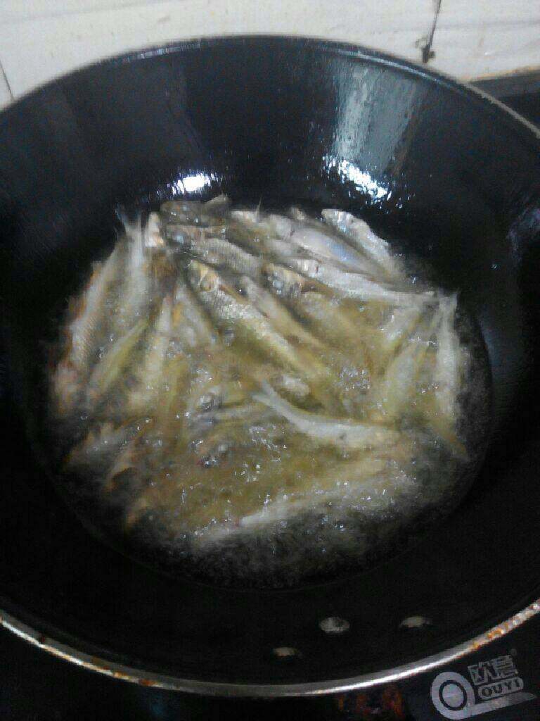小鱼烧咸菜,油锅里放入适量的油将小鱼炸一下，炸的定型后就倒出多余的油