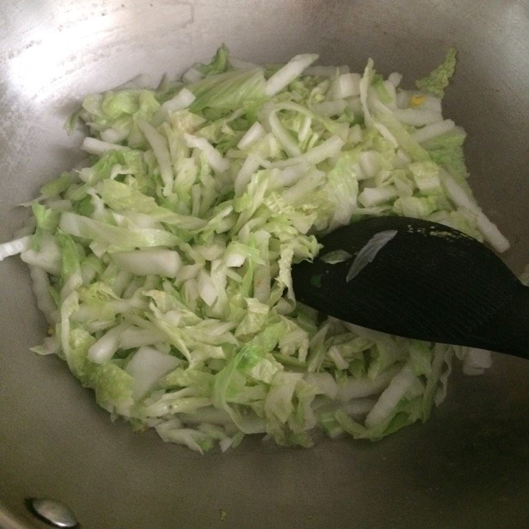 白菜年糕,如图起油锅，6分热时下入切好的白菜（最好切得细一点）煸炒，加入适量盐、糖继续翻炒；