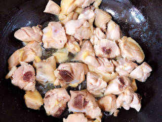家常鸡块,锅中倒入油，加热至五成热，放入鸡块翻炒均匀，炒去水份。