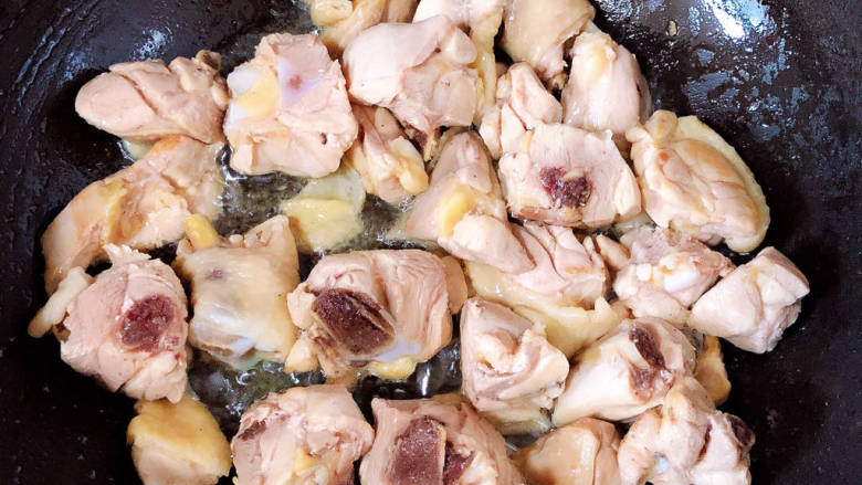 家常鸡块,锅中倒入油，加热至五成热，放入鸡块翻炒均匀，炒去水份。