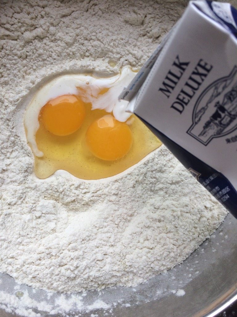 回族点心【油香】,如图打入两个鸡蛋，加纯牛奶