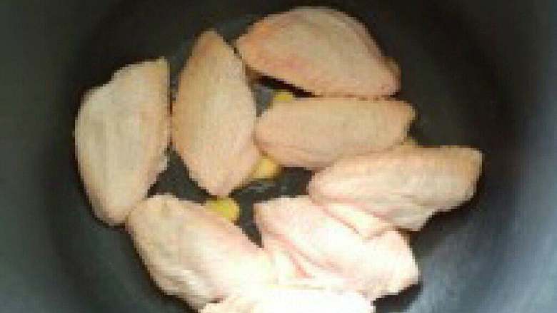 一步骤做可乐鸡翅,3. 放进鸡翅。姜片要放在鸡翅底 下，去腥，防止粘锅。