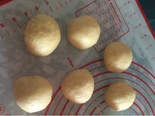 椰香豆沙卷面包,如图取出面团排气，均匀地分割成6份，滚圆后醒面10分钟；