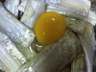 干炸带鱼,如图在腌好的带鱼段里打一个鸡蛋拌匀
