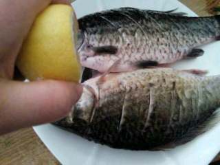 剁椒烧鲤鱼,用刀把鱼身划出口子方便入味，用柠檬汁挤满鱼身加适量盐腌制一下。