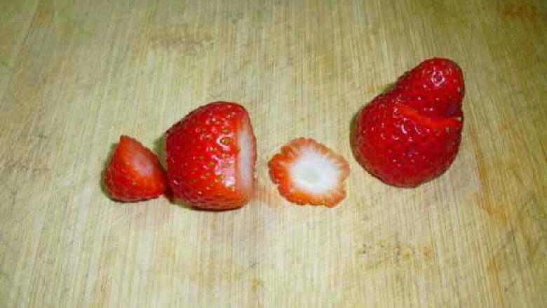 草莓雪人,底部切平，用小刀在三分之一处切开，上半部分做雪人的帽子，下半部分做身子。
