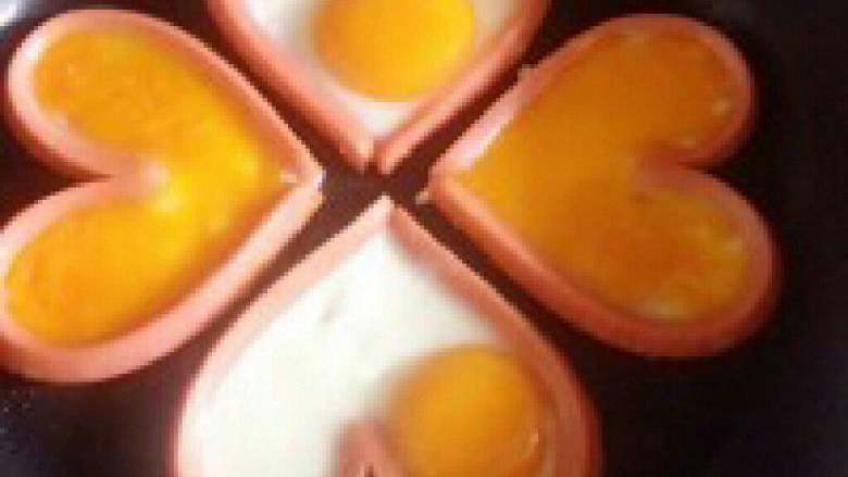 爱心煎蛋, 做好爱心以后 ，开火 ，火不要大 哦 锅热后 ，就可以将<a style='color:red;display:inline-block;' href='/shicai/ 9'>鸡蛋</a>打入心形 里了， 喜欢吃全熟的，将蛋打好后 ，可以用勺子将蛋黄轻轻的挑破，将蛋黄浇均匀 这样更漂亮 。