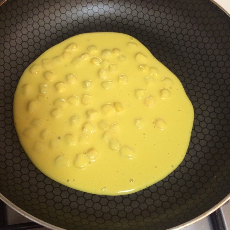 奶香黄金玉米饼,如图平底锅小火加热，倒入适量面糊，转动锅柄使面糊基本呈圆形；