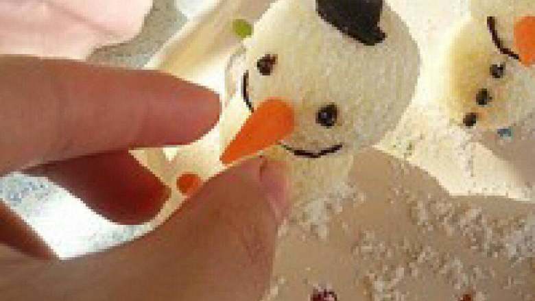 圣诞雪人威风蛋糕,巧克力隔水融化做成帽子形状放 入冰箱，拿出来粘在雪人上，用胡 萝卜削成鼻子的造型，用一小段牙 签弄好鼻子。
