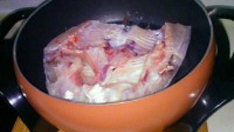 自制【鱼头豆腐火锅】,锅烧热，倒适量多些的油，把鱼 头放入中火慢煎。