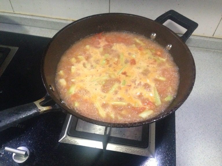 素豆角,加入西红柿继续煸炒，加入适量水，加盐，中火满炖，如图