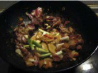 自制【腊肉炖土豆火锅】,加入姜蒜、花椒和蒜白翻炒均匀。