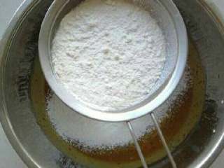 红糖枣糕的家常做法,9. 牛奶蛋黄液中加入过筛的低粉，泡打粉和小苏打。
