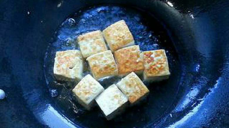 豆腐土豆烧肉的做法,豆腐土豆烧肉的家常做法,锅中放置2勺<a style='color:red;display:inline-block;' href='/shicai/ 406'>猪油</a>，至油温升起，将豆腐切成小方块后，用开水烫一下去除豆腥味；放进一半的豆腐入锅中小火煎炸。