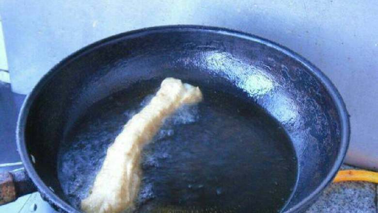 无矾健康油条,轻轻放入油锅炸制。用筷子翻动，炸至到金黄色即可。