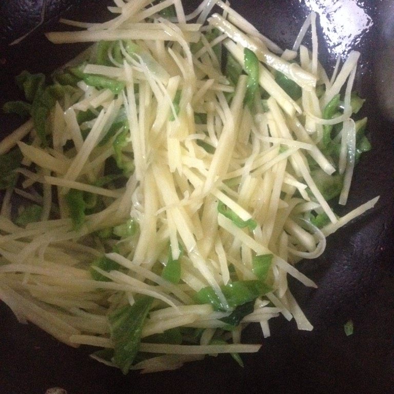 青椒土豆丝,如图锅里放入适量的油，烧至八成热 倒入土豆丝，炒熟即可