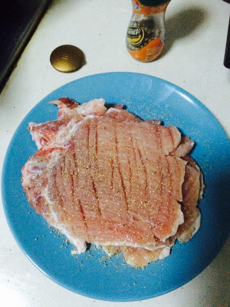 烤箱版炸猪排,猪排洗净用刀背拍松，边上切几口防止肉筋收缩。加盐和黑胡椒粒腌制20分钟