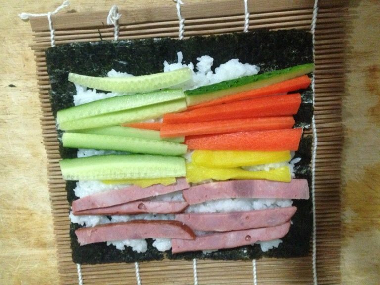 寿司,将切好的食材平铺在米饭上，如图