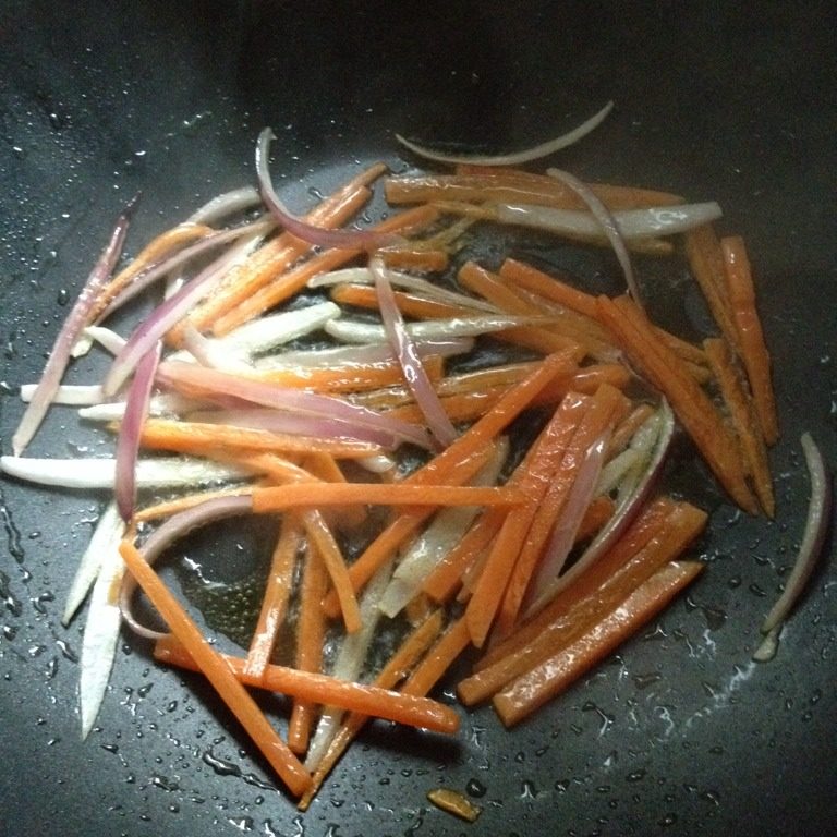 韩式炒年糕,锅里放少许油，油热后放胡萝卜丝、洋葱丝、盐翻炒，