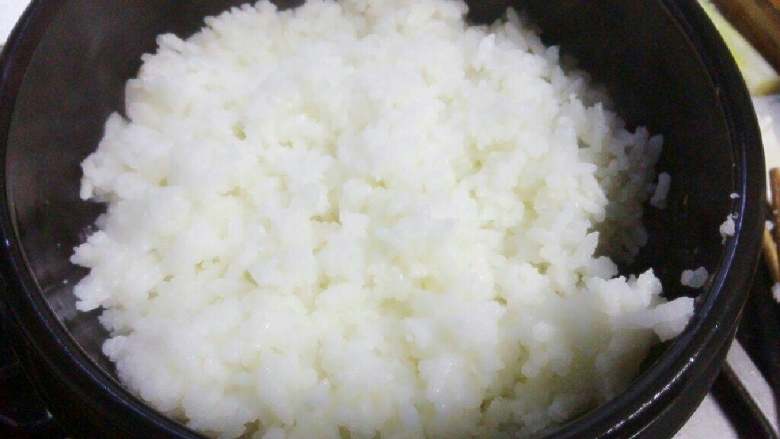 石锅拌饭,石锅中薄薄涂一层香油，铺好熟米饭。
