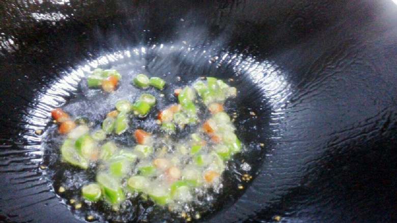 辣白菜豆腐汤,锅底倒少量油，中火加热。倒入青红椒段翻炒几下。