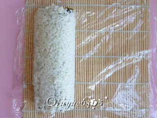 翻转樱花寿司,然后放开寿司帘，把保鲜膜重新铺平。
