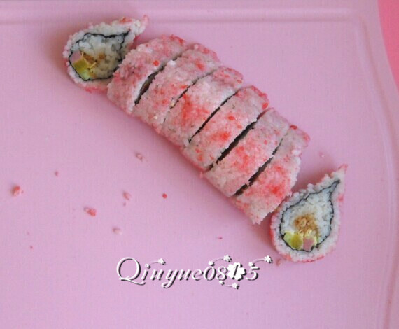 翻转樱花寿司,用刀切去两端不规整的，然后把寿司切成匀称的小段。